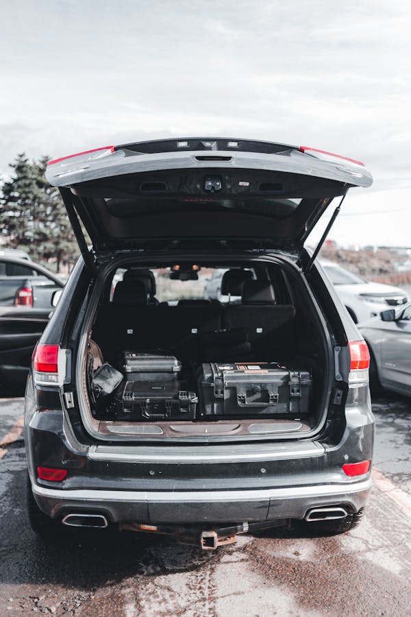 Open car trunk with tools and tire being stowed
